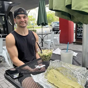 a man sitting at an outdoor table