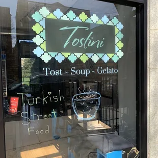 a glass window with a sign that says tostini