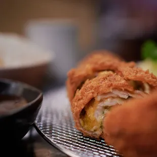 a fried egg roll on a plate with dipping sauce