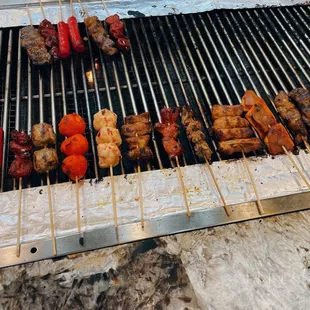 skewers of meat and vegetables on a grill