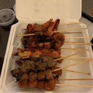 skewers of meat and vegetables in a styrofoam container