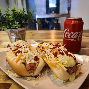 two hot dogs with coleslaw and a coke