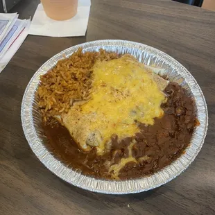 Beef sunken burrito dinner with refried beans and rice.