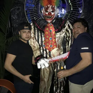 two men standing next to a clown statue