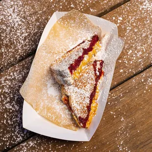 a half eaten sandwich with powdered sugar