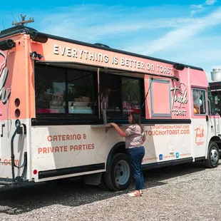 a woman standing in front of a food truck