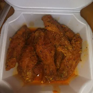 a closeup of a chicken dish in a styrofoam container