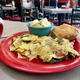 Veggie surprise omelet, biscuit, and fruit salad.