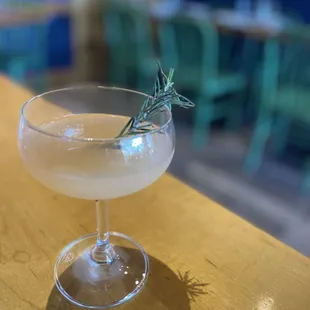 a glass of wine with a sprig of rosemary