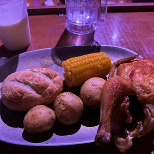 Cornish hen with roasted potatoes, corn on the cob and roll. My piña colada and Sprite is in the background.