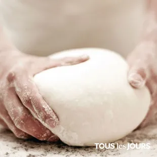 a person holding a ball of dough