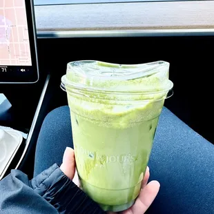 a person holding a green smoothie