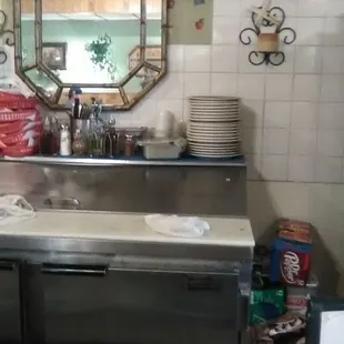 a stainless steel counter with a mirror above it