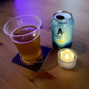 a glass of beer and a lit candle