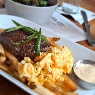 Steak and eggs on fries with a side of brussel sprouts