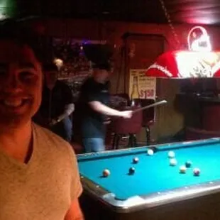 a man standing in front of a pool table