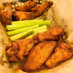 a basket of chicken wings and celery