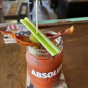 a bloody drink with bacon and celery