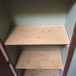 Cupboard shelves dirty.