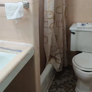 Tiny bathroom with a toilet that doesn&apos;t flush and is apparently the spot of a murder scene according to papers and motel history.