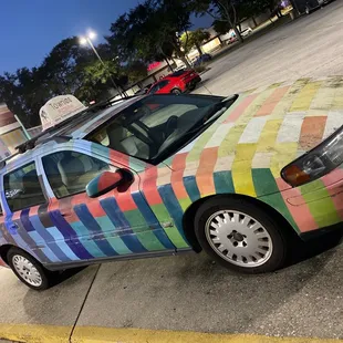 a multicolored car parked in a parking lot