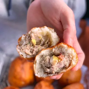 a person holding a half eaten bun