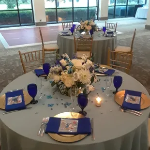 Table setting: TPC mirror center, gold chargers, cobalt blue waterglasses, royal blue napkins. bayberry table linens, gold chairs