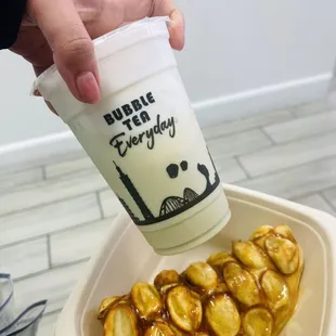 a person holding a cup of bubble tea