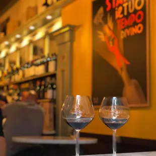 two wine glasses on a bar