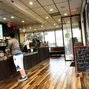 a person standing at a counter in a coffee shop