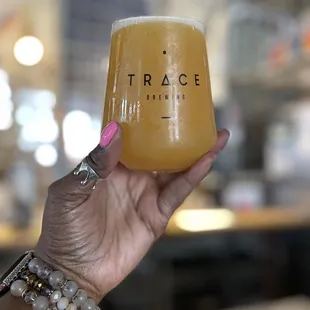 a hand holding a glass of beer