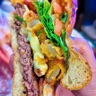a person holding a sandwich in their hand