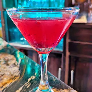 a red drink in a martini glass