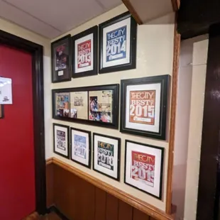 a hallway with a red door and picture frames on the wall