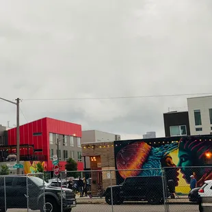 cars parked in a parking lot in front of a red building