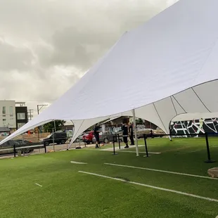 a man standing under a large white tent