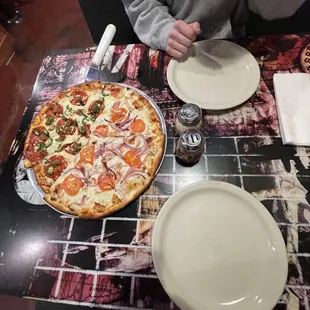 a man sitting at a table with a pizza on it