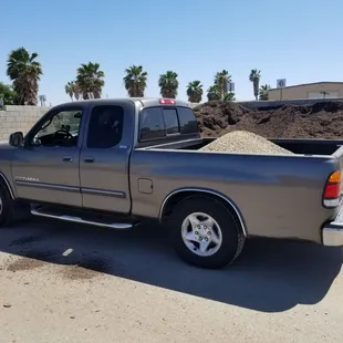 a pick up truck with a pile of dirt in the back