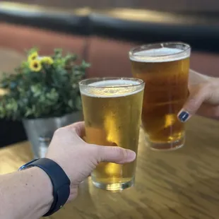 two people clinking glasses of beer