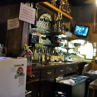 a bar with a fridge and a television