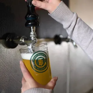 a person pouring a beer
