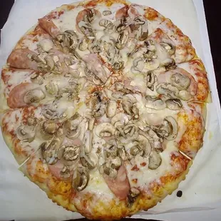 ows a pizza with mushrooms and ham