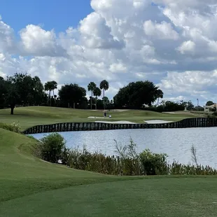 a golf course with a lake in the foreground