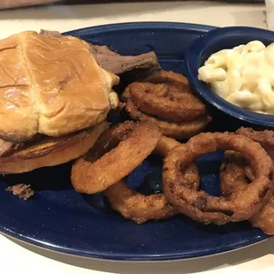Brisket dinner sandwich with onion rings and Mac n cheese