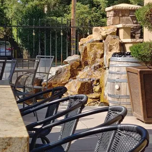 Outdoor seating includes a small waterfall fountain in the corner.