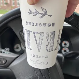 a hand holding a coffee cup