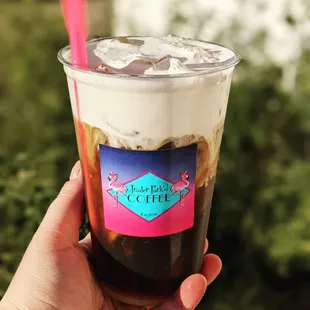 a hand holding a cup of iced coffee