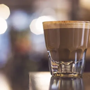 a glass of coffee on a table