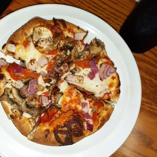 Small pizza with mushrooms, onions,  and pepperoni.