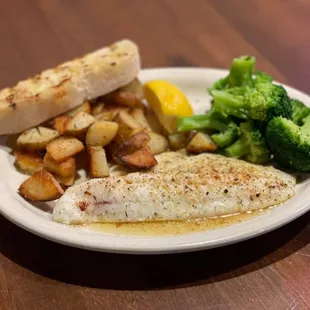 a plate of fish, potatoes, and broccoli